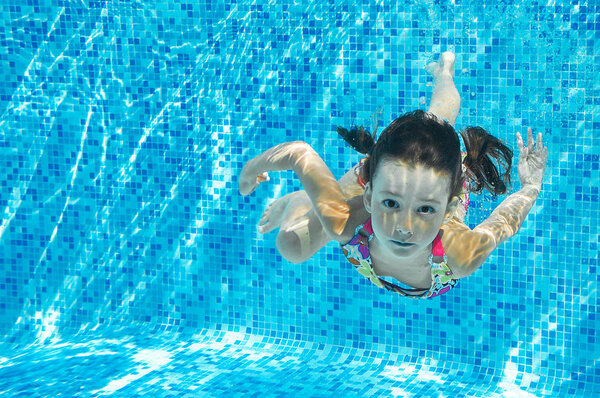 Ребенок плавает в бассейне под водой, счастливая активная девушка ныряет и веселится, детский фитнес и спорт на семейном отдыхе
