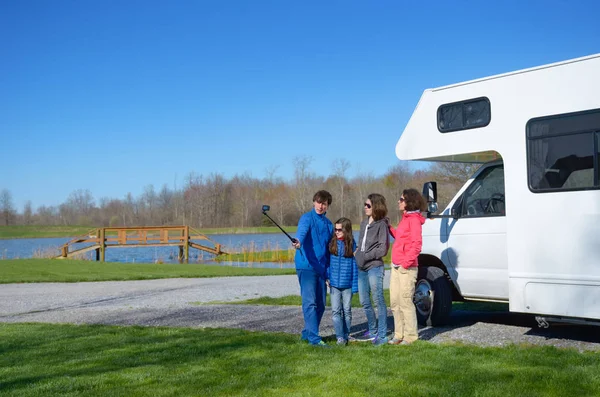 Férias em família, viagem de RV com crianças, pais felizes com crianças se divertir e fazer selfie em viagem de férias em motorhome, campista exterior — Fotografia de Stock