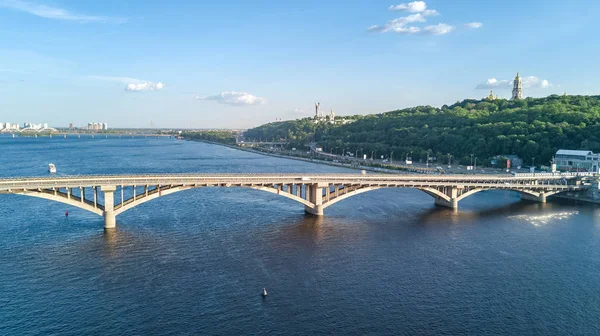 Aerial top view of Metro railway bridge with train and Dnieper river from above, skyline of city of Kiev, Ukraine — Stock Photo, Image