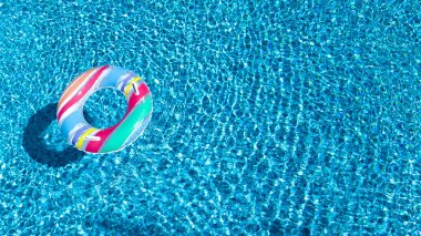 Renkli şişme halka çörek oyuncak Yüzme Havuzu su yukarıdan, Aile tatil kavramı arka plan havadan görünümü