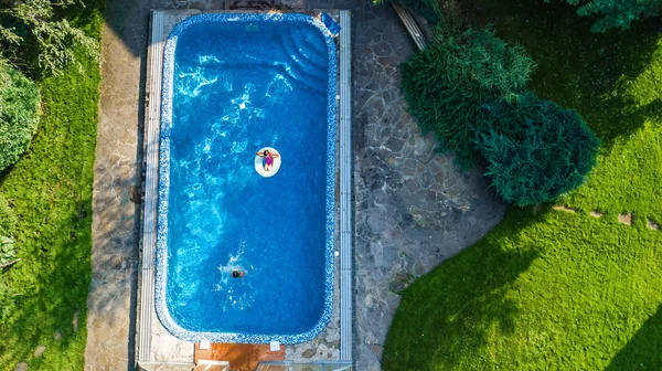 Luchtfoto van zwemmen zwembad above, kinderen zwemmen en veel plezier in water op familie vakantie in hotel resort — Stockfoto