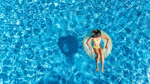 Letecký pohled na dívku v bazénu shora, kid plavat na nafukovací prstenec kobliha a zábavu ve vodě na rodinnou dovolenou — Stock fotografie