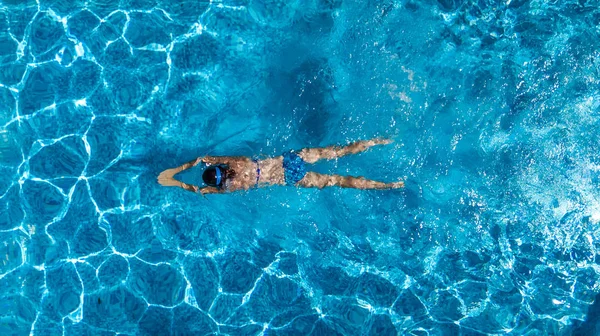 Luftaufnahme einer Frau im Schwimmbadwasser von oben, tropisches Urlaubskonzept — Stockfoto