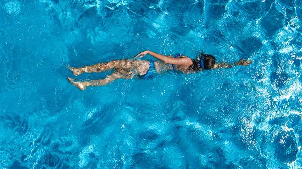 Luftaufnahme einer Frau im Schwimmbadwasser von oben, tropisches Urlaubskonzept — Stockfoto