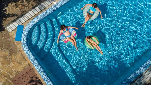 Vista aerea dall'alto della famiglia in piscina dall'alto, madre e bambini nuotano e si divertono in acqua durante le vacanze in famiglia in hotel resort — Foto Stock