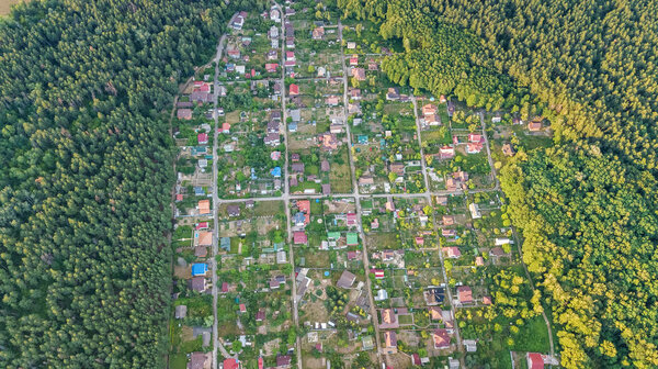 Aerial top view of residential area summer houses in forest from above, countryside real estate and small dacha village in Ukraine