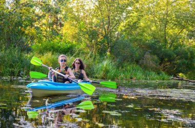 Aile kanosu, anne ve çocuk kano turunda kano, aktif yaz tatili ve tatil, spor ve spor konsepti