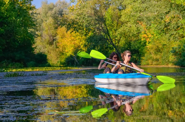 Family kayaking, mother and child paddling in kayak on river canoe tour, active summer weekend and vacation, sport and fitness concept