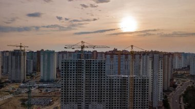 Yukarıdan, Ukrayna Kiev şehrinin kentsel silüeti gün batımında Vinçler ile yerleşim bölgesinde binaların inşaat sitesinin havadan görünümü