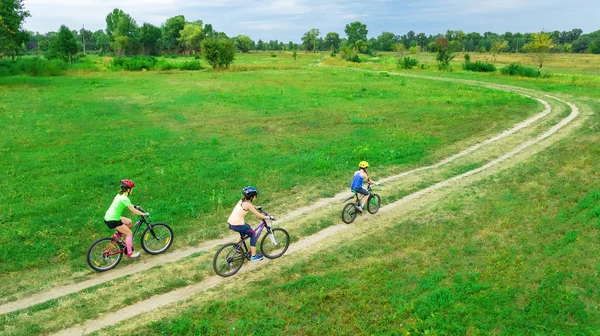 Bisikletle gezen aile yukarıdan hava manzaralı mutlu aktif anne çocuklarla eğleniyor, aile sporu ve spor yapıyor. — Stok fotoğraf