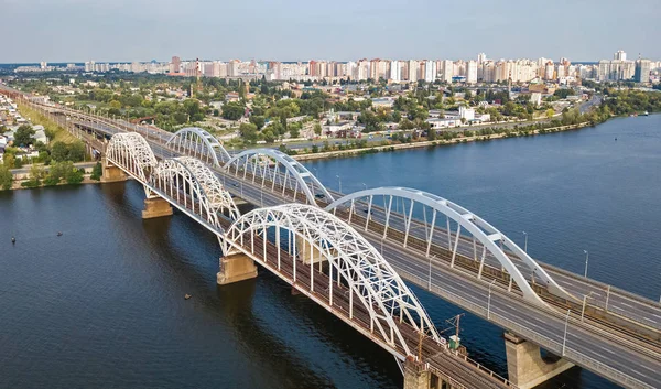 Översta Flygfoto av bil- och järnväg Darnitsky bron över floden Dnepr ovanifrån, Kiev (Kiev) stadens silhuett, Ukraina — Stockfoto
