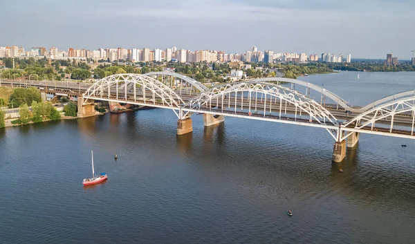 Vista aérea superior da ponte Darnitsky, iates e barcos navegando no rio Dnieper de cima, horizonte da cidade de Kiev (Kiev), Ucrânia — Fotografia de Stock