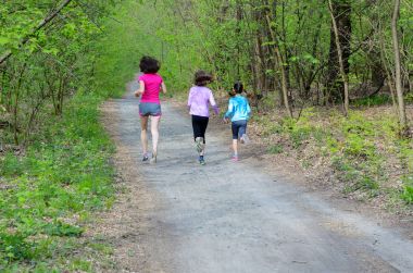 Aile fitness ve spor, mutlu etkin anne ve açık havada jogging, ormanda koşu çocuklar