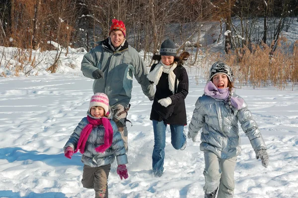 Familia feliz en invierno, divirtiéndose con nieve al aire libre en fin de semana — Foto de Stock