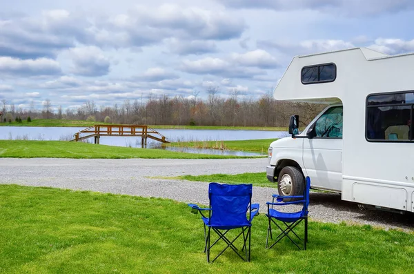 Camper (kampeerauto) en stoelen in de camping, familie vakantie reizen, vakantiereis in camper — Stockfoto