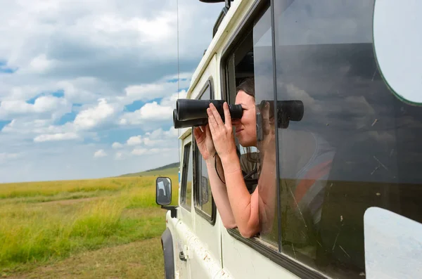 Mulher turista em safári na África, viajar no Quênia, assistindo a vida selvagem em savana com binóculos — Fotografia de Stock