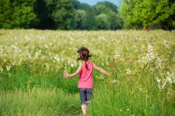 Kind auf der grünen Frühlingswiese, Kind läuft und hat Spaß im Freien — Stockfoto