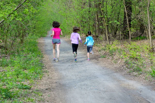 Fitness familiar y deporte, madre activa feliz y niños corriendo al aire libre, corriendo en el bosque —  Fotos de Stock
