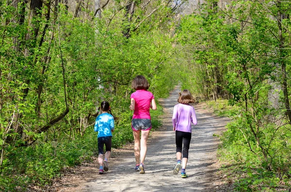 Aile fitness ve spor, mutlu etkin anne ve açık havada jogging, ormanda koşu çocuklar — Stok fotoğraf