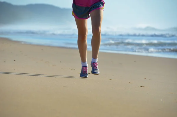 Fitness y correr en la playa, piernas corredoras de mujer en zapatos trotando en la arena cerca del mar, estilo de vida saludable y concepto de deporte —  Fotos de Stock
