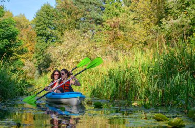 Aile Kayak, anne ve çocuk nehir Kano turu, etkin sonbahar hafta sonu ve tatil, spor ve fitness kavramı içinde kayık kürek çekmeye