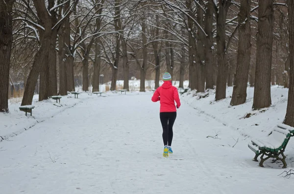 冬の公園での実行 幸せなアクティブな女性ランナーの雪 アウトドア スポーツとフィットネスの概念でジョギング — ストック写真