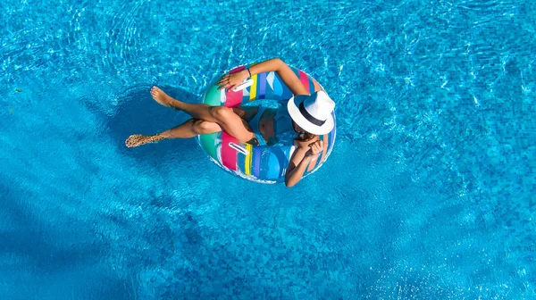 Hava üstten görünüm güzel kızın yukarıdan, yüzme havuzunda Yüzme şişme halka çörek üzerinde dinlenmek ve eğlenir suda ailecek tatile