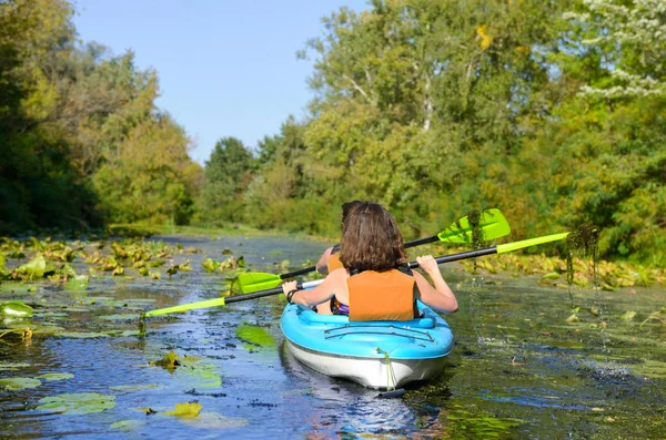 Family kayaking, mother and child paddling in kayak on river canoe tour having fun, active autumn weekend and vacation, fitness concept