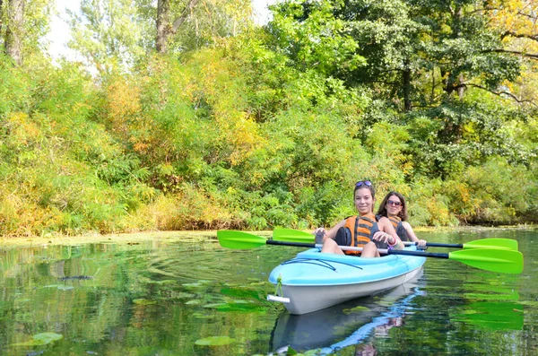 Family kayaking, mother and child paddling in kayak on river canoe tour having fun, active autumn weekend and vacation, fitness concept