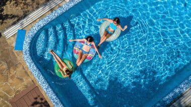 Hava üstten görünüm Yüzme Havuzu yukarıdan, mutlu anne ve çocuklar aile şişme halka çörek üzerinde yüzmek ve su aile tatil, tropikal tatil tatil eğlenmek