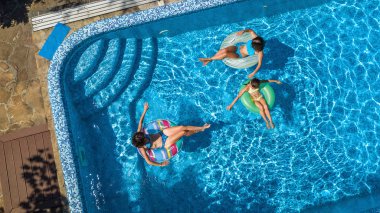 Hava üstten görünüm Yüzme Havuzu yukarıdan, mutlu anne ve çocuklar aile şişme halka çörek üzerinde yüzmek ve su aile tatil, tropikal tatil tatil eğlenmek