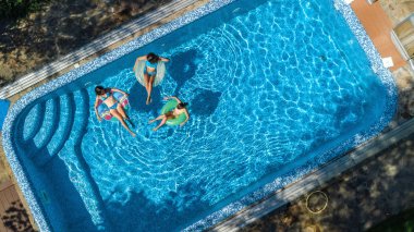 Hava üstten görünüm Yüzme Havuzu yukarıdan, mutlu anne ve çocuklar aile şişme halka çörek üzerinde yüzmek ve su aile tatil, tropikal tatil tatil eğlenmek