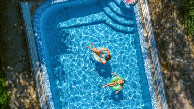 Hava üst yukarıdan, yüzme havuzunda çocukların mutlu çocuklar yüzmek şişme üzerinde çörek halka ve aile tatil tatil tatil eğlenmek suda görüntülemek