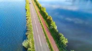 Otoyol manzarası ve polder barajındaki bisiklet yolu, Kuzey Hollanda, Hollanda 'dan gelen arabalar.