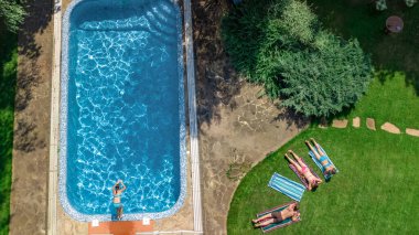 Mutlu aile yüzme havuzu ile rahatlatıcı, ebeveynlerin yukarıdan havadan drone görünümü ve çocuklar tatilde eğlenin, tatil aile hafta sonu