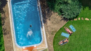Mutlu aile yüzme havuzu ile rahatlatıcı, ebeveynlerin yukarıdan havadan drone görünümü ve çocuklar tatilde eğlenin, tatil aile hafta sonu