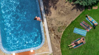 Mutlu aile yüzme havuzu ile rahatlatıcı, ebeveynlerin yukarıdan havadan drone görünümü ve çocuklar tatilde eğlenin, tatil aile hafta sonu