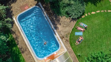 Mutlu aile yüzme havuzu ile rahatlatıcı, ebeveynlerin yukarıdan havadan drone görünümü ve çocuklar tatilde eğlenin, tatil aile hafta sonu