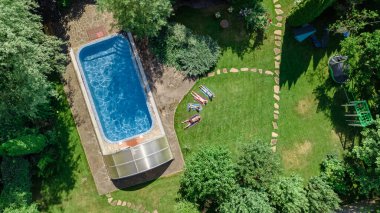 Mutlu aile yüzme havuzu ile rahatlatıcı, ebeveynlerin yukarıdan havadan drone görünümü ve çocuklar tatilde eğlenin, tatil aile hafta sonu