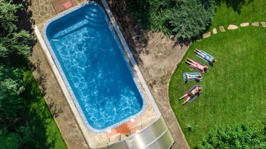 Mutlu aile yüzme havuzu ile rahatlatıcı, ebeveynlerin yukarıdan havadan drone görünümü ve çocuklar tatilde eğlenin, tatil aile hafta sonu