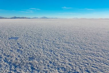 Bolivya 'daki Salar de Uyuni manzarası su, tuz düzlüğü çöl ve gökyüzü yansımaları ile kaplıdır.
