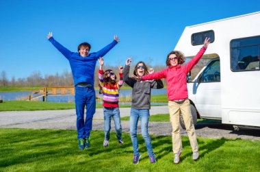 Aile tatili, çocuklarla karavan gezisi, çocuklu mutlu ebeveynler karavanda tatilde eğlenmek, karavan gezisi.