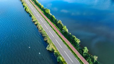 Otoyol manzarası ve polder barajındaki bisiklet yolu, Kuzey Hollanda, Hollanda 'dan gelen arabalar.