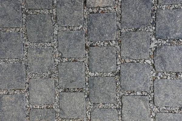 Square stones, paved road.