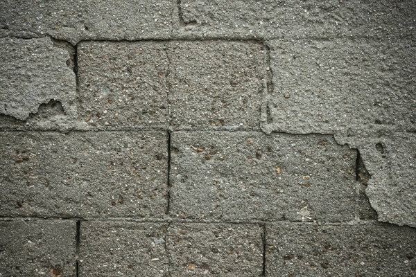 Under the crumbling plaster visible bricks, masonry. Rough cold texture, grunge. Gray tones, vignetting.