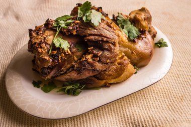 Büyük bir parça et, sarımsak ve baharatla pişirilmiş domuz budu. Geleneksel ev yemekleri, basit yemekler. Işık arkaplan, gün ışığı.