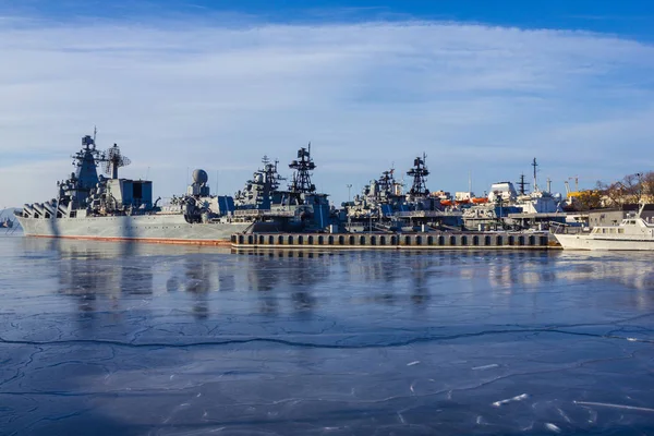 灰色的船 一个军事中队靠近城市的海岸 基地的地方 寒冷的天气 海面上覆盖着冰 早春太阳能照明 — 图库照片