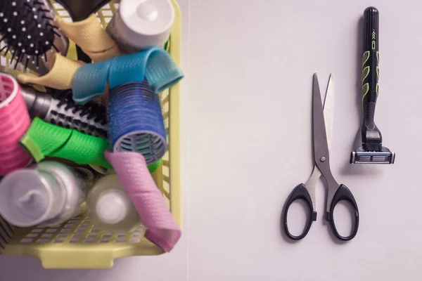 The problem of hair loss, baldness. In the garbage basket set for hair care. Next scissors and a razor. Change of image, short haircut. View from above.