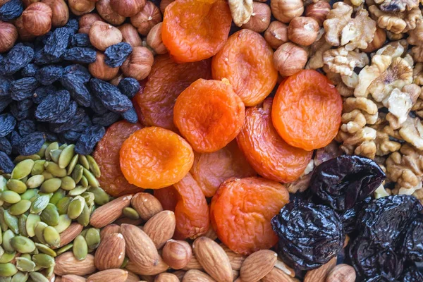 Dried apricots, raisins, almonds, hazelnuts, walnuts, prunes and pumpkin seeds. Bright, colorful background, natural shades. Organic food, vegetarian cuisine.