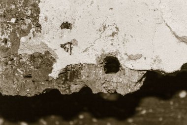 Beton, çimento, tuğla yüzey, duvar. Çatlaklar, çipler, ortada yuvarlak bir delik. Arkaplan bulanık.